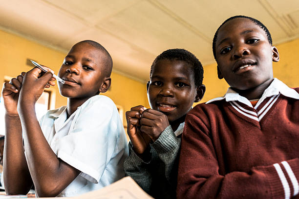 tres estudiantes africano amarillo en un montaje tipo aula - african descent africa african culture classroom fotografías e imágenes de stock