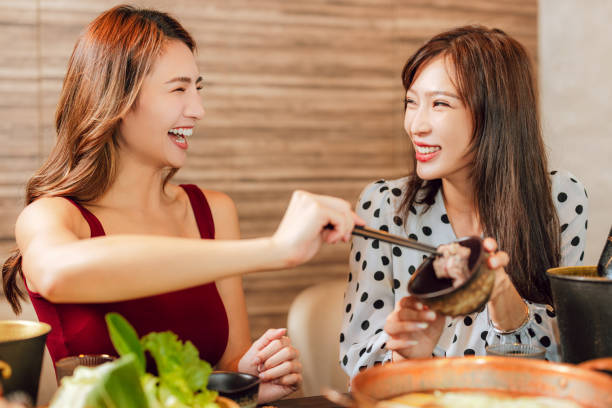 Happy woman dining in hotpots restaurant