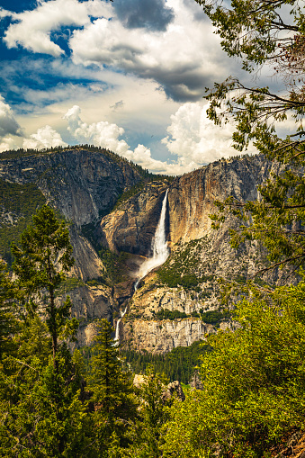 Storm forming over Yosemite Falls at peak flow on a sunny day in summer in 2023, Yosemite Valley, National Park, California, USA.