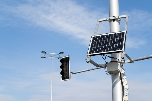Solar powered traffic signal light. Solar panel on a pole with a traffic lights.