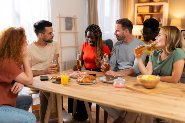 istock Group of multi-ethnic friends talking while sitting together at dining table. 1562401429