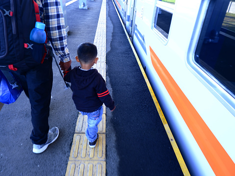 The father who was holding his son to take the train, train station
