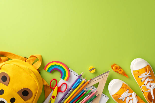 istock Stimulate interest among parents and educators with top view shot, presenting a yellow rucksack with a range of colorful school supplies on light green isolated backdrop for educational campaigns 1562407800