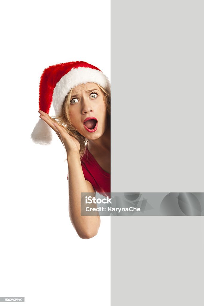Веселая молодая женщина в рождественской шляпе, держа пустой Рекламный щит - Стоковые фото Афиша роялти-фри