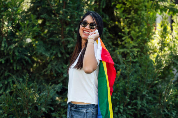 istock Young Asian woman holding rainbow flag 1562481125