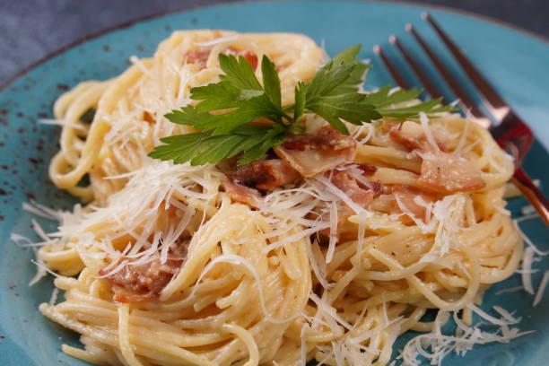 istock Carbonara pasta, spaghetti with  bacon, egg, hard parmesan cheese and cream sauce. Traditional Italian cuisine. 1562485498