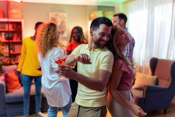 istock Young couple dancing back to back at house party. 1562500407