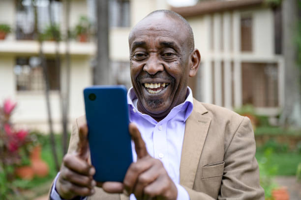 istock Laughing Nairobi man using smart phone outdoors 1562501991