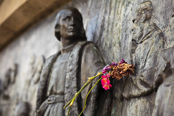 istock Closeup of flowers placed on Christopher Columbus statue arm 156251166