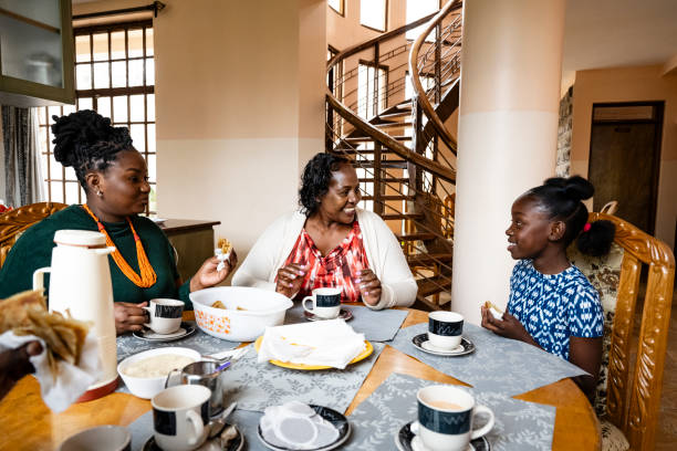 Three generations of African women enjoying chapatti and tea