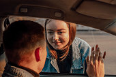 girl saying goodbye to boy through a car window before travel