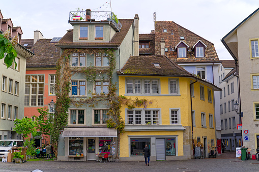 Alley at the medieval old town of City of Winterthur with colorful facades of historic houses on a cloudy spring day. Photo taken May 17th, 2023, Winterthur, Switzerland.