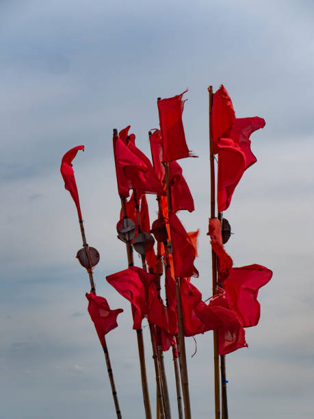 istock Red flags warning signal fishing port 1562551220