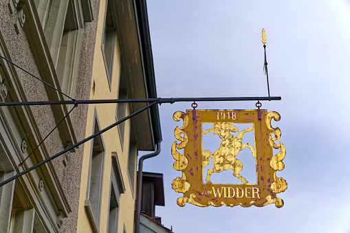 Facades of historic houses with golden sign with ram at the old town of Swiss City of Winterthur on a cloudy spring day. Photo taken May 17th, 2023, Winterthur, Switzerland.