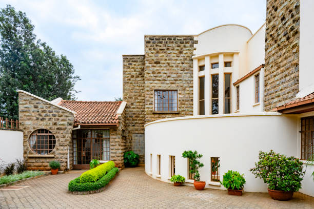 Gökçeada, Turkey – August 24, 2024: Rustic stone house bathed in golden sunset light, surrounded by lush greenery and traditional wooden fence – perfect for Mediterranean lifestyle or countryside architecture concepts.