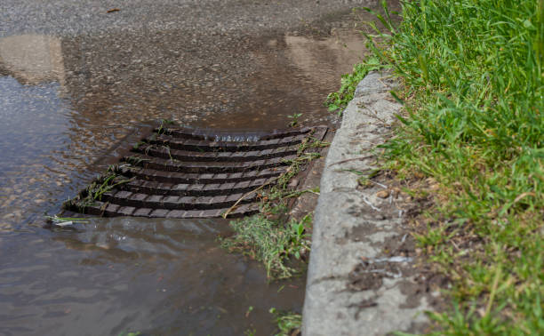 istock Stormwater sewer flooded after rain near sidewalk. 1562581028