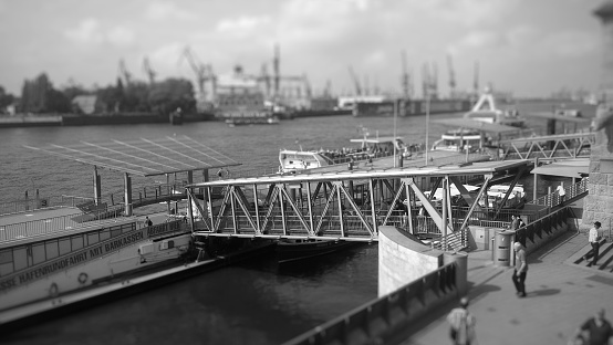 In the foreground the tidal wall and the landing bridges to the ships and boats.  In the background the other side of the river with the district Steinwerder. Photo was taken on the Elbe River in the Hamburg district of St. Pauli.