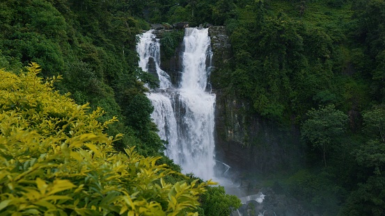 Ramboda Falls. Sri Lanka. Powerful stream of water in rocky mountains. High quality 4k footage. Waterfall cascade in tropical forest. Distant view. Nuwara Eliya.