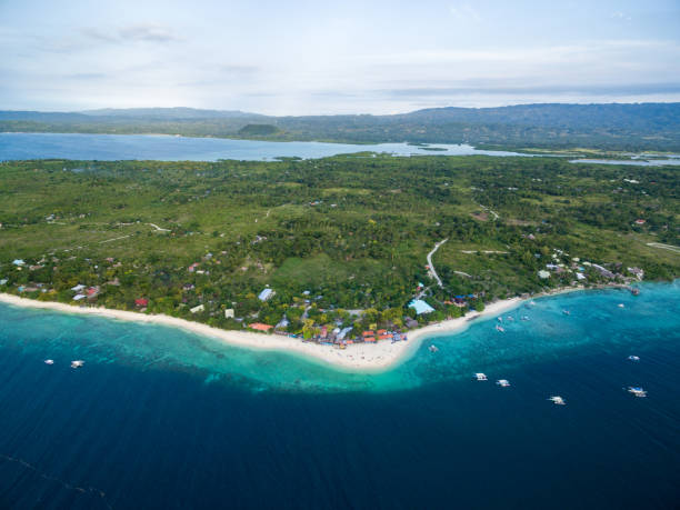 istock White Beach Moalboal in Cebu, Palawan, Philippines. Boat and Ocean Water and Beach. 1562598708