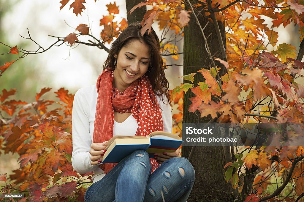 Chica joven leyendo libro en el parque otoño - Foto de stock de Adolescente libre de derechos