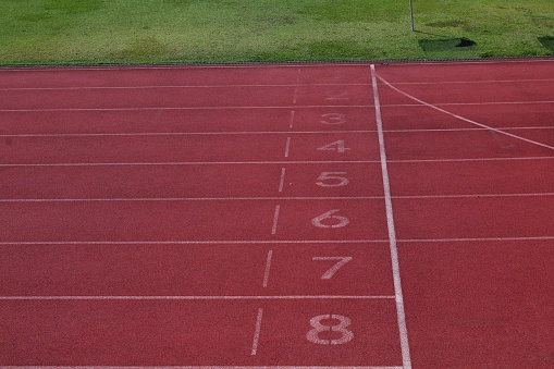 running track on the edge of the field with numbers from one to eight