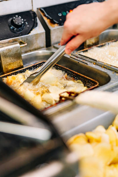 istock Chef cooking delicious potato chips in hot oil on kitchen 1562625475