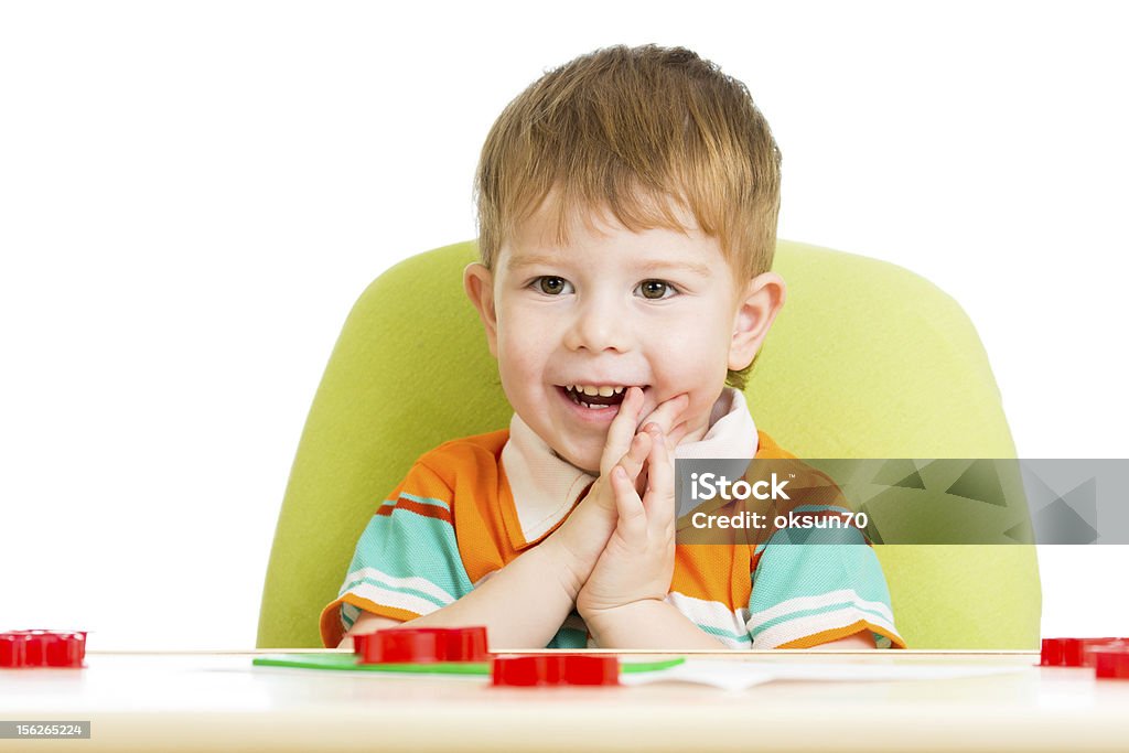 Happy kid sentado en la mesa tocando con colorido de arcilla - Foto de stock de Alegre libre de derechos