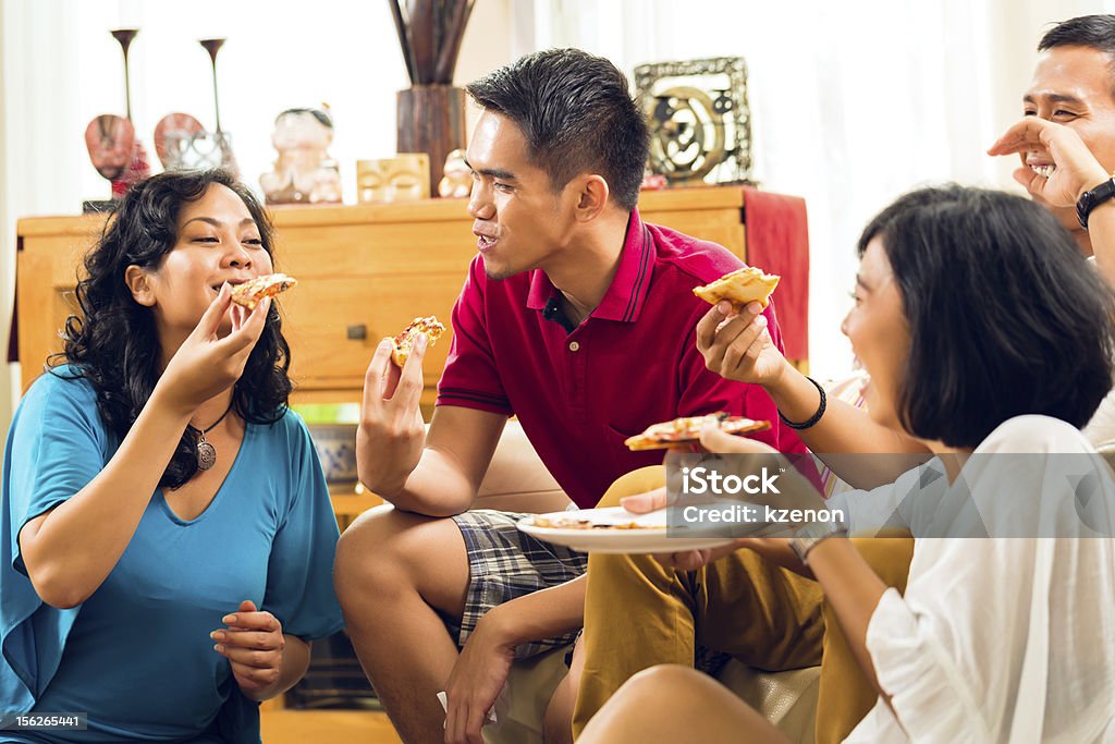 Asian people eating pizza at party Asian people eat pizza at party and laugh Adult Stock Photo