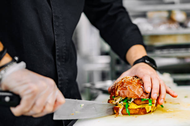 istock burger with beef, tomato, cheese, and lettuce chef cutting on kitchen 1562657284