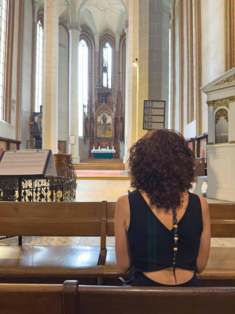 istock Woman pray in church 1562662096