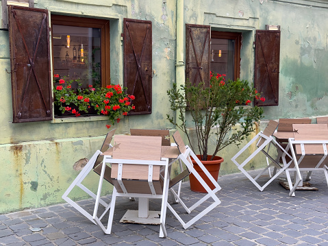 A wooden chair painted with floral patterns in a traditional Aegean courtyard and a bicycle in the background