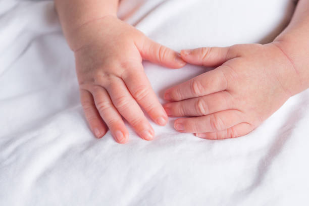istock Hands of newborn baby on white cloth 1562706096