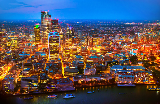 London, UK - 23 July, 2019: City of London business and banking area at nigh with beautiful lit up skyscrapers and streets.