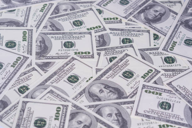 istock Top view pile of one hundred dollars as background. 1562712610