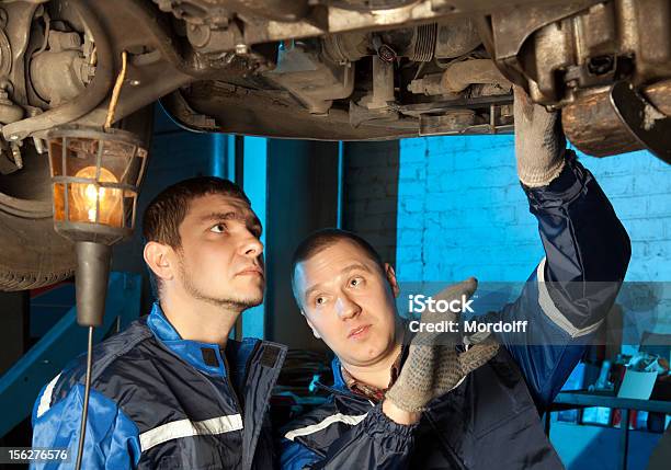 Dos Mecánicos Trabajando Bajo Auto En Tienda De Reparaciones Foto de stock y más banco de imágenes de Adulto