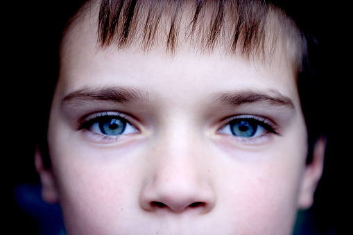 Young boy looking directly into camera.