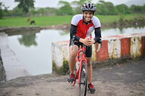 istock Active cyclist wearing protective gear, beaming with joy as he poses with his bicycle for the camera. 1562774989
