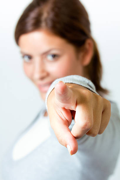 istock young woman pointing at the camera 156277581