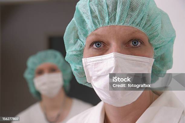 Dos Enfermeras Wearing Red Para Cabello Y Máscara Quirúrgica Foto de stock y más banco de imágenes de Adulto