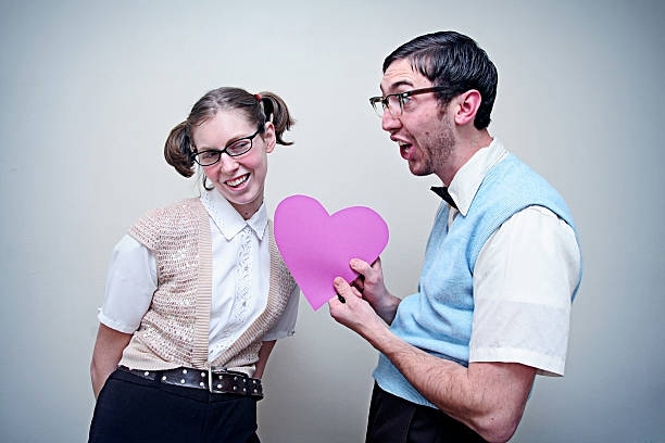 rapaz e rapariga gira de caixa-de-óculos apaixonado segurando um coração - valentines day love nerd couple imagens e fotografias de stock