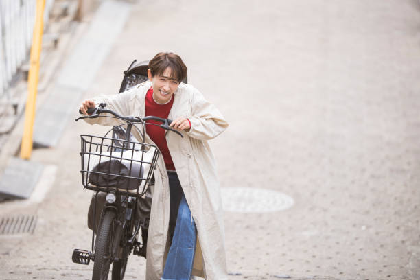 日本人女性の生活シーン、電動自転車。