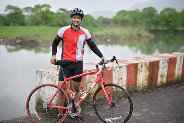 istock Portrait of an active cyclist with his bicycle, wearing protective gear 1562806384
