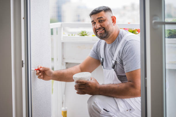 istock Man putting color on walls via paint brush 1562831285