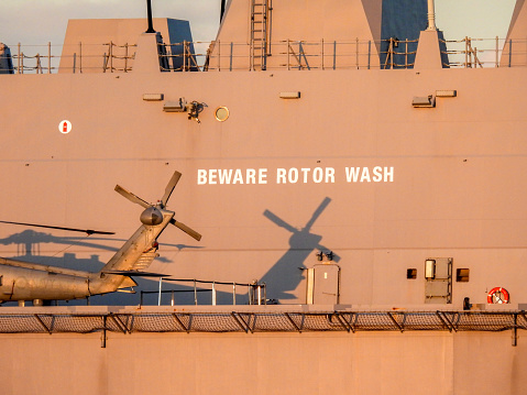 HMAS Canberra is a Canberra-class amphibious assault ship of the Royal Australian Navy.  She is docked at Garden Island, Sydney Harbour for the commissioning ceremony of USS Canberra.  On her deck is a Sikorsky MH-60R Seahawk helicopter, registration N48-013, named \