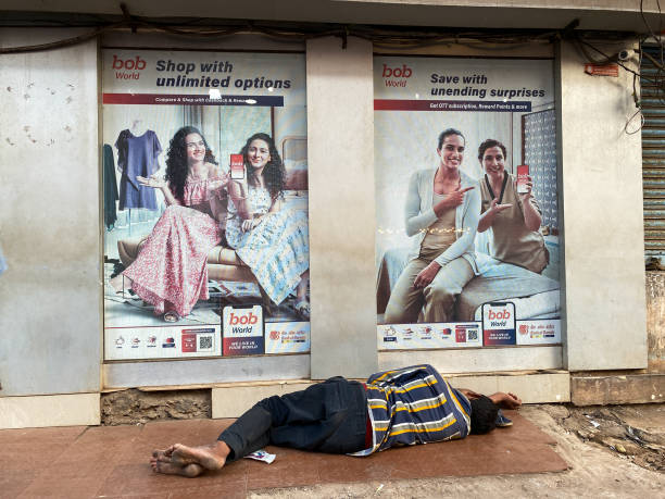 A LABOR SLEEPS ON A BUSY STREET IN NEW DELHI OF INDIA.