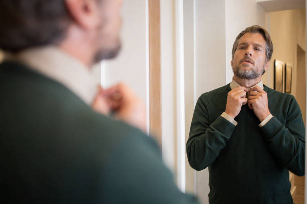 istock Businessman getting dressed in front of the mirror 1562846530