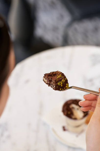 istock woman eats tiramisu from a spoon 1562854613