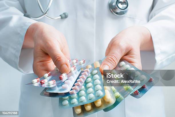 Doctor Holding Out Several Packs Of A Variety Of Pills Stock Photo - Download Image Now