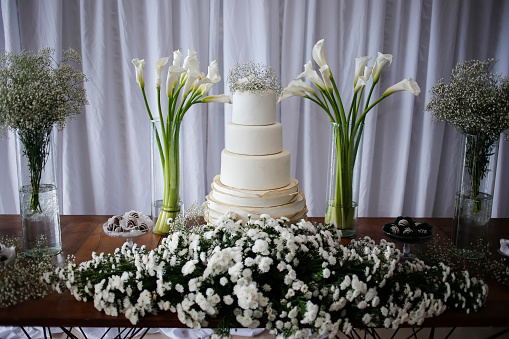 wedding table - elegant white table with cake and flowers decorated for wedding party