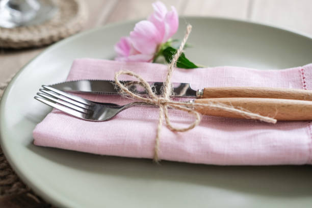 istock Close-up cutlery. Romantic table setting with pink peonies 1562938885
